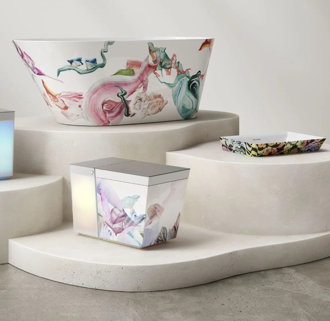 A collection of ceramic vessels decorated with colorful floral prints displayed on layered, organic-shaped, off-white stone or concrete tiers against a light neutral background.
