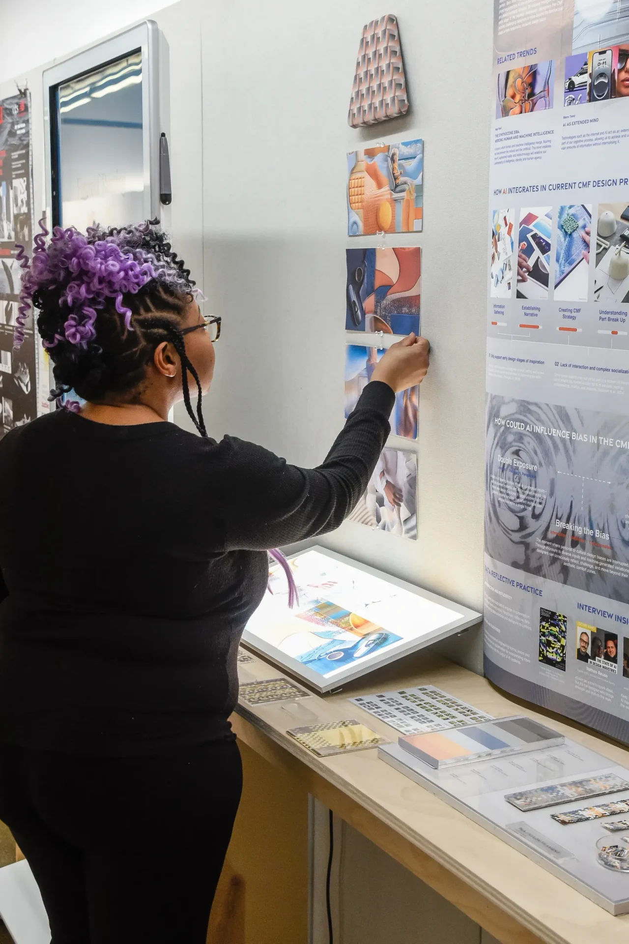 Color & Materials Design student reviewing work on a wall.