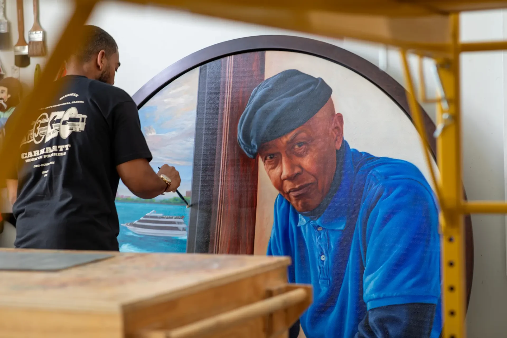 Mario Moore in his studio with his painting “Blues Man: Allie at Home.”