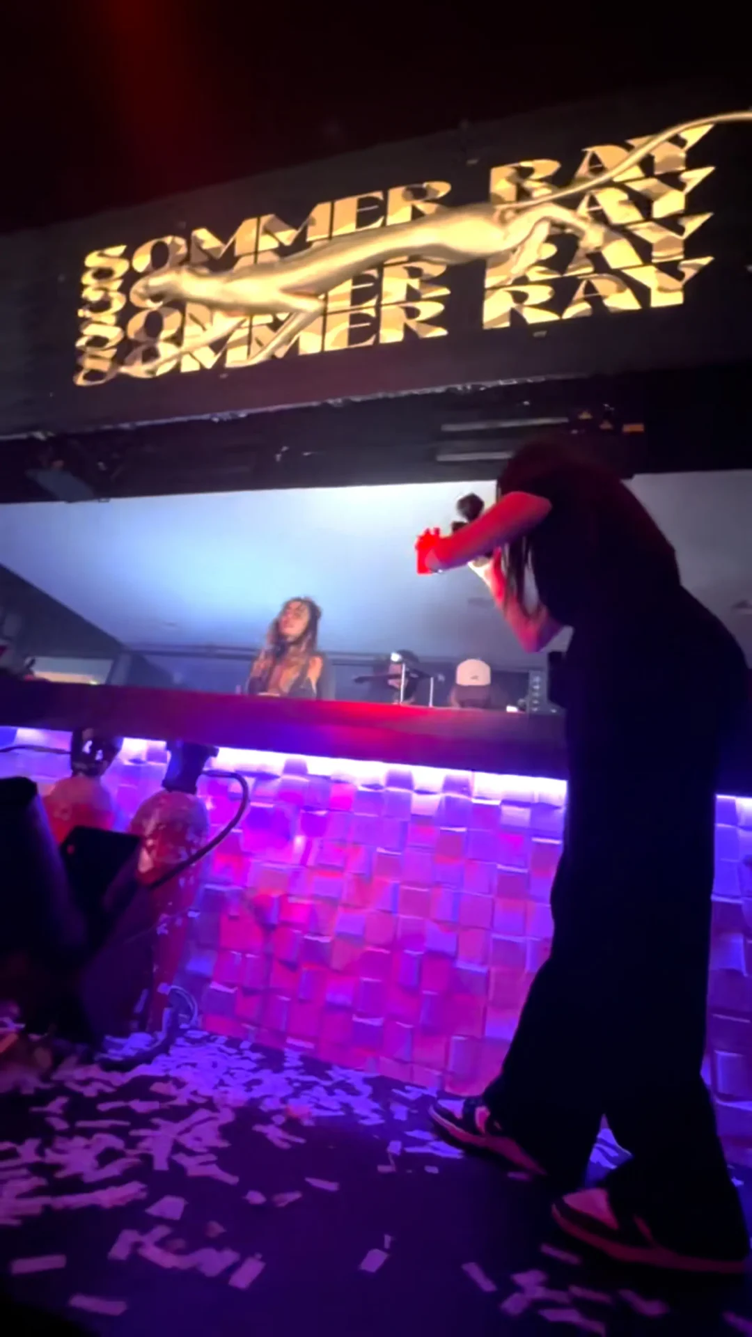 Behind the scenes shot of Annabelle Saco filming artist, Sommer Ray as she DJs at a club.