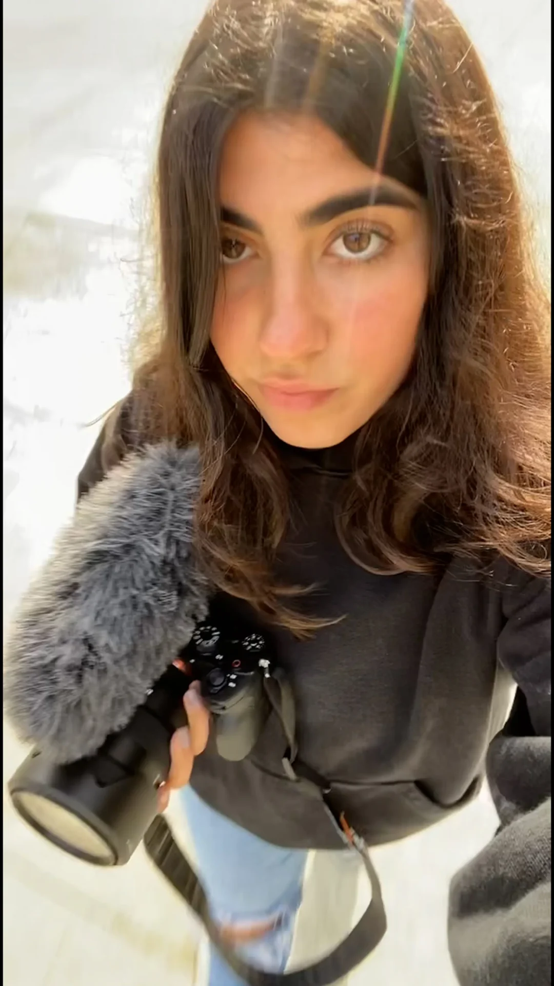 Behind the scenes selfie of Annabelle Saco holding a professional video setup on her way to a shoot outdoors.