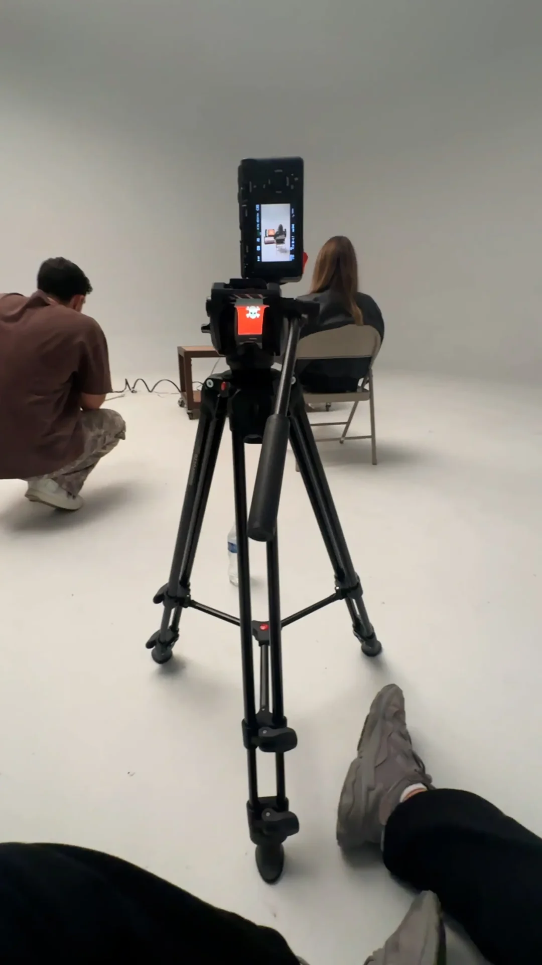 Annabelle Saco behind the scenes on a photo stage featuring a camera on a tripod.