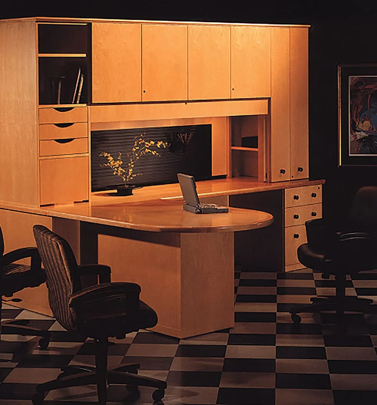 A light colored wooden office desk with drawers and cabinets.