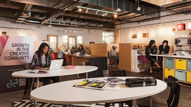 Various people working at tables and working stations in the Design Core Detroit hub