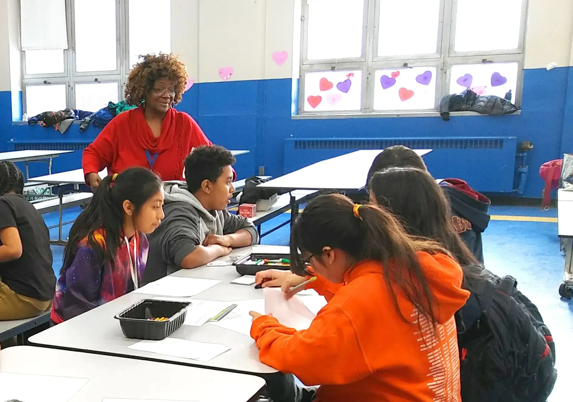 Kids working at a table with an adult supervising