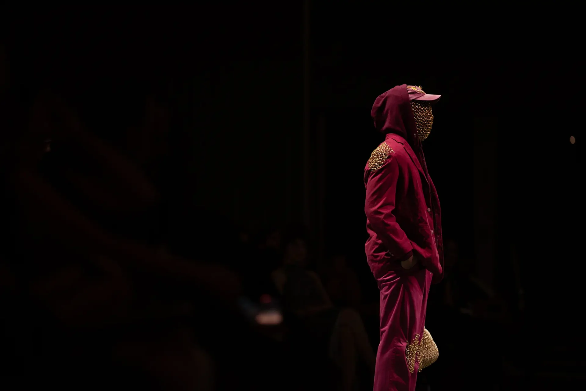 Male model wearing a red suit with metal chain details