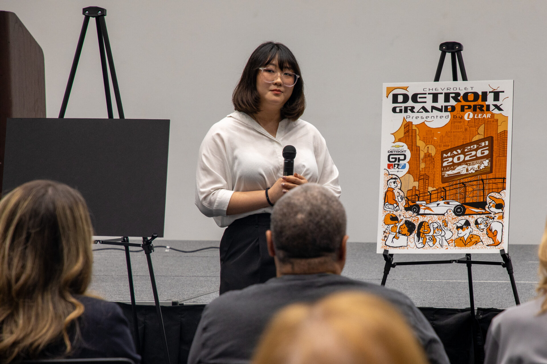 A student presents her work in a large conference room to judges for the annual CCS X Grand Prix project.