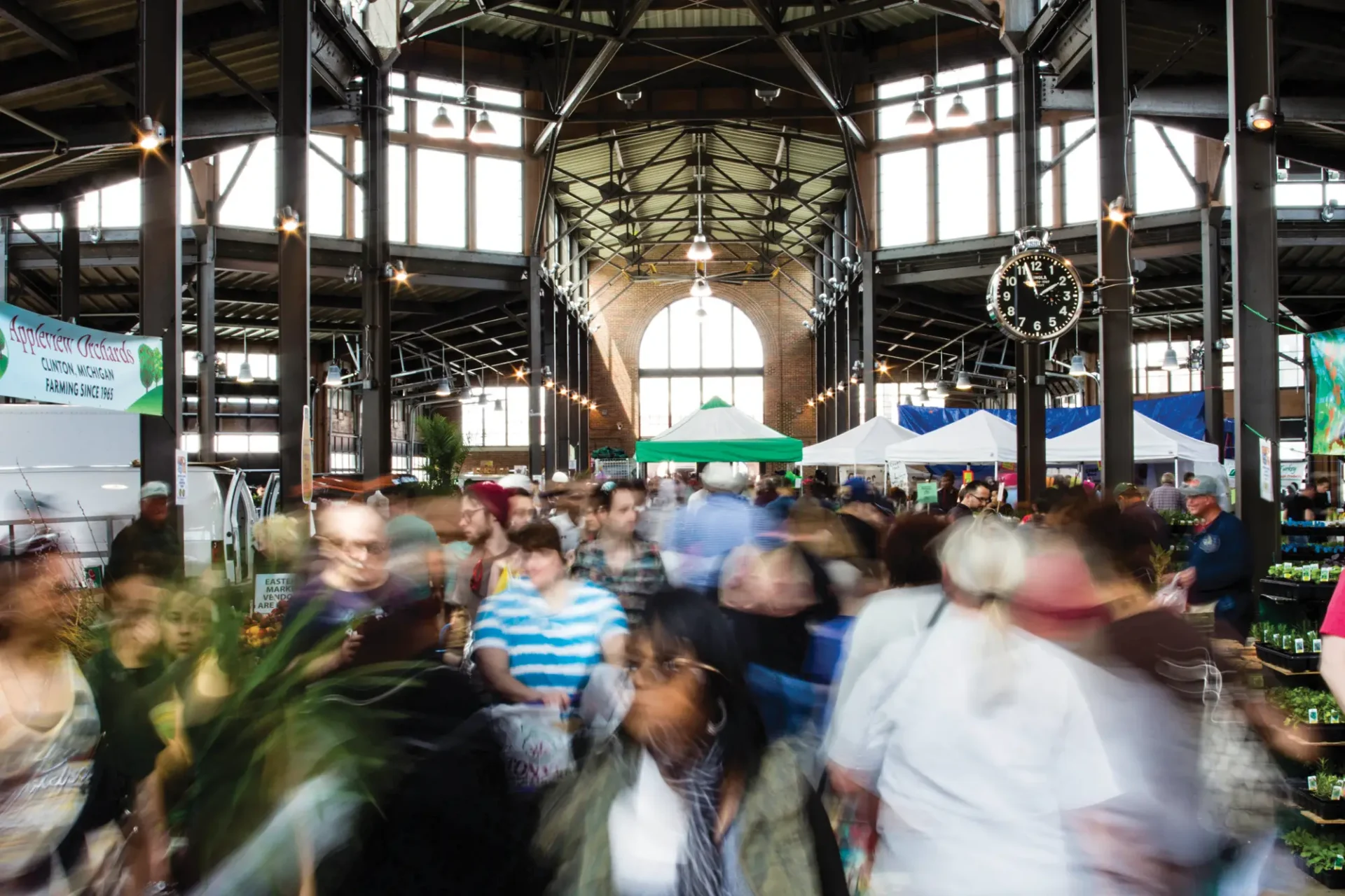 A blurred image of people moving around under an Eastern Market shed