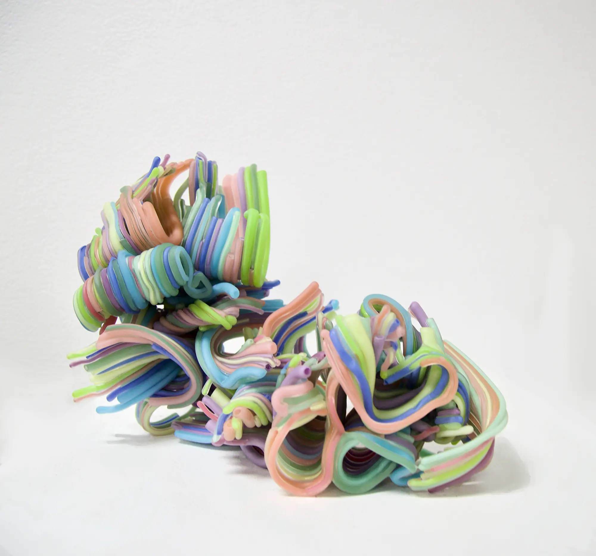 An organic, colorful figure comprised of intertwining glass tubes