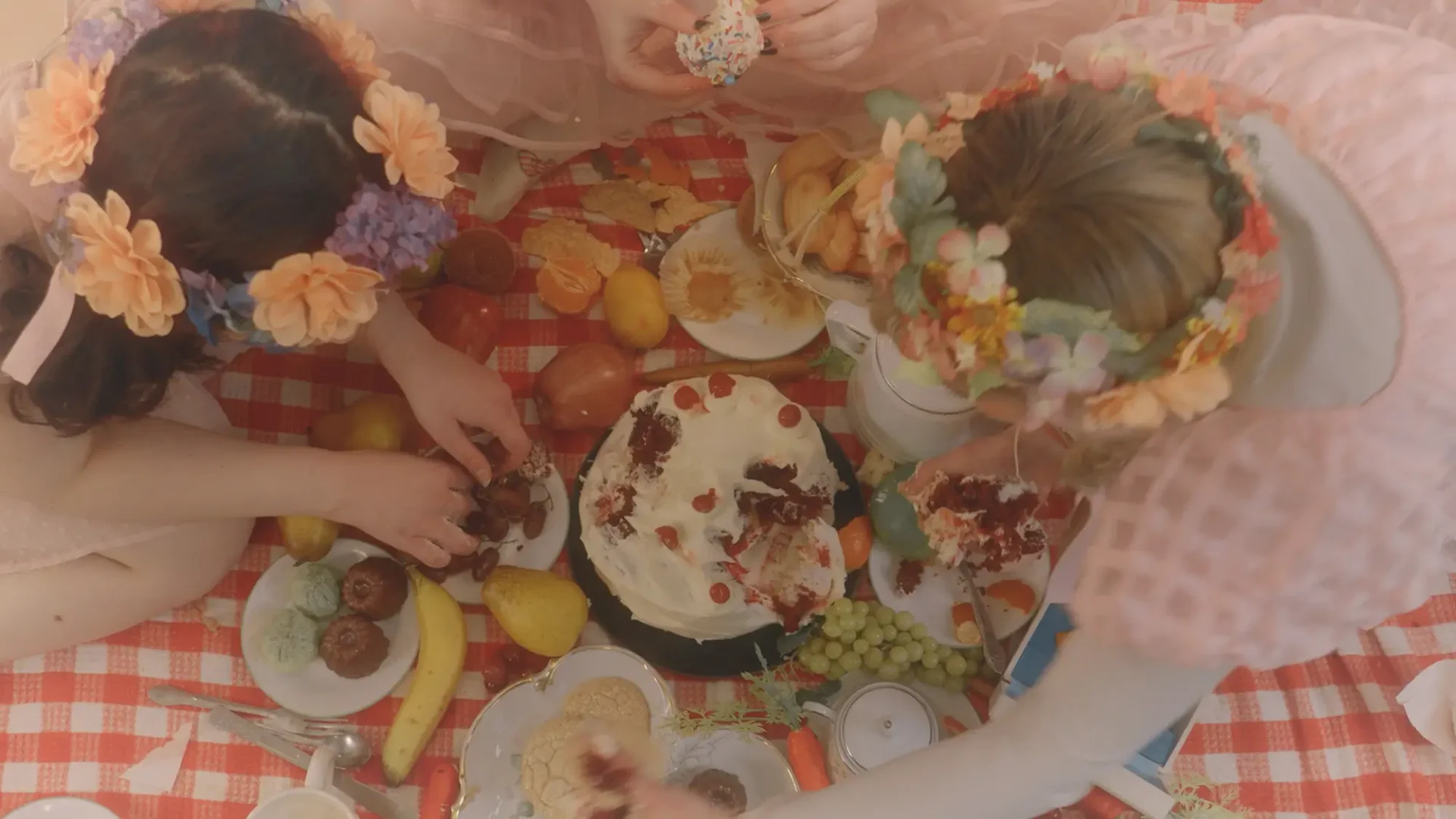 Film still from MASH: Birds-eye view of three girsl having a ravenous picnic.