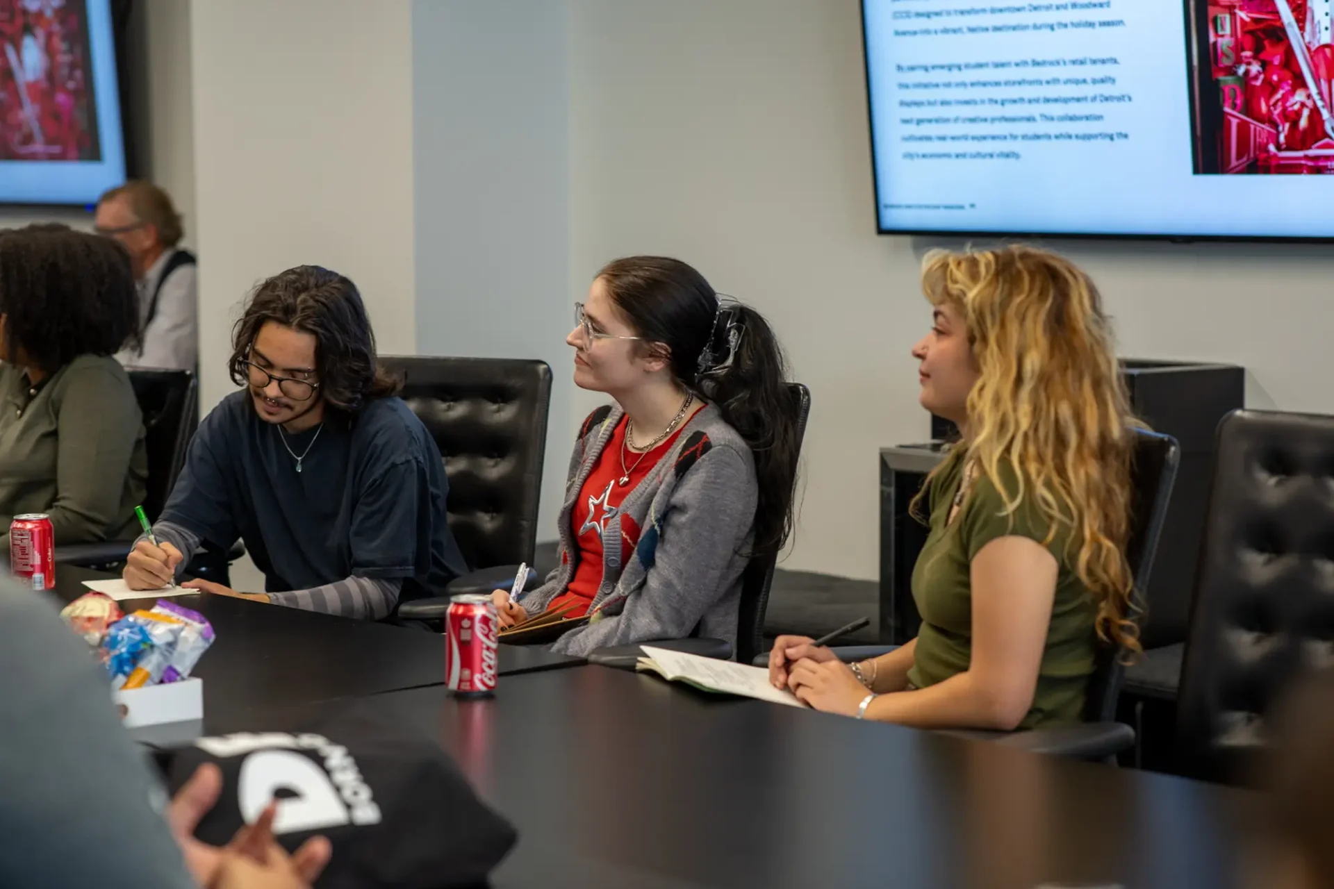 A group of students at a table looking at a screen