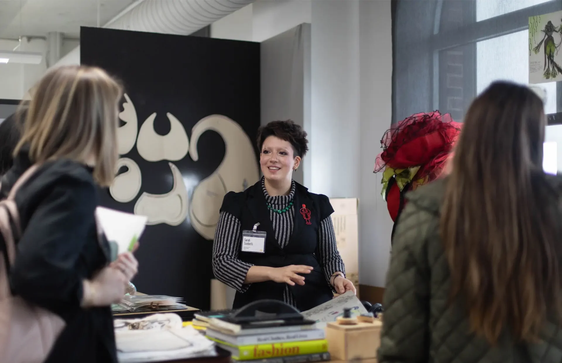 3 women around a table, smiling and speaking to one another