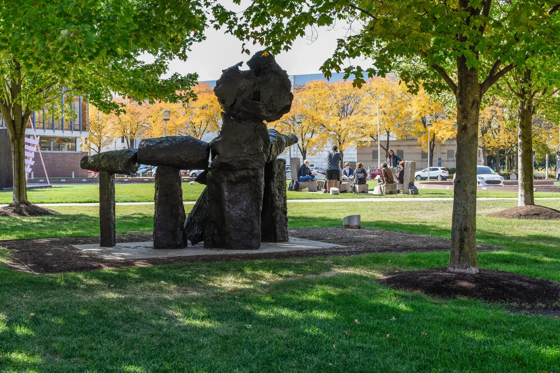 A shot of the Sculpture garden. A group of students is gathered in a group in the background