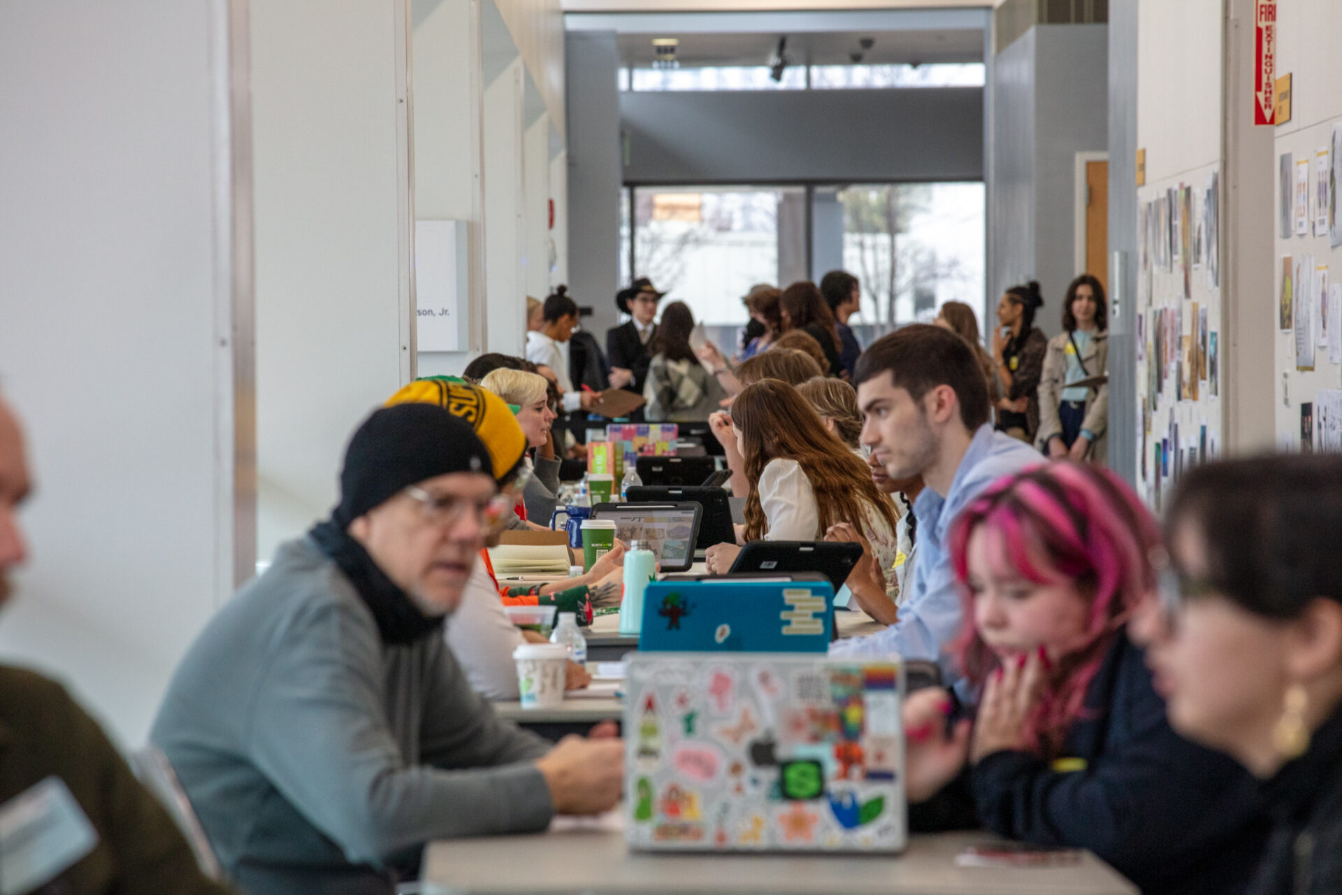 Students sitting at a long row of tables having portfolio reviews with industry professionals and the annual Entertainment Industry Exposion.