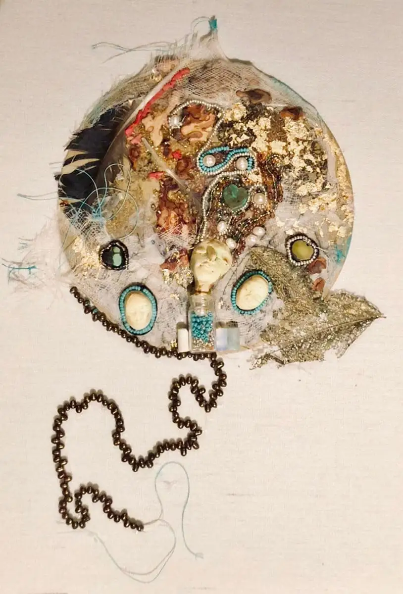 Mixed media collage in the shape of a circle using found objects including leaves, beads, stones, and feathers by Amy Ruopp