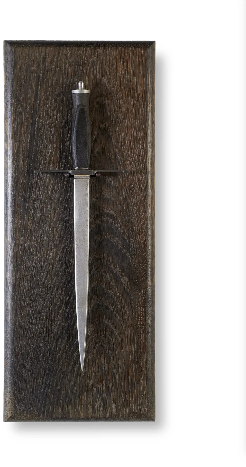 Big pointy dagger mounted on wooden plaque