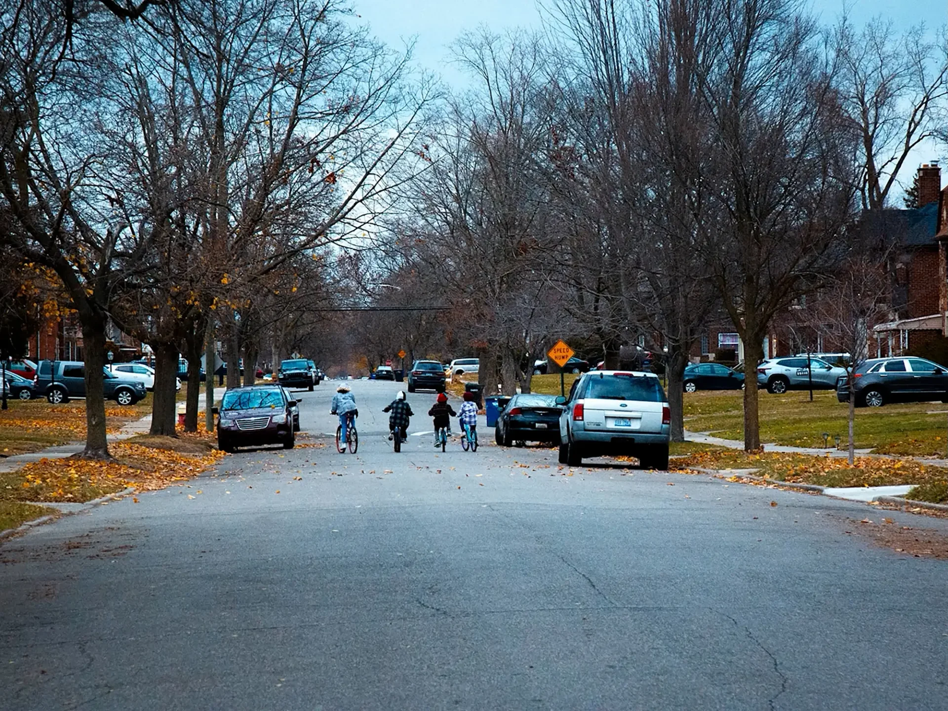 Still from freshman narrative: 4 kids ride bikes through the neighborhood in a wide shot.