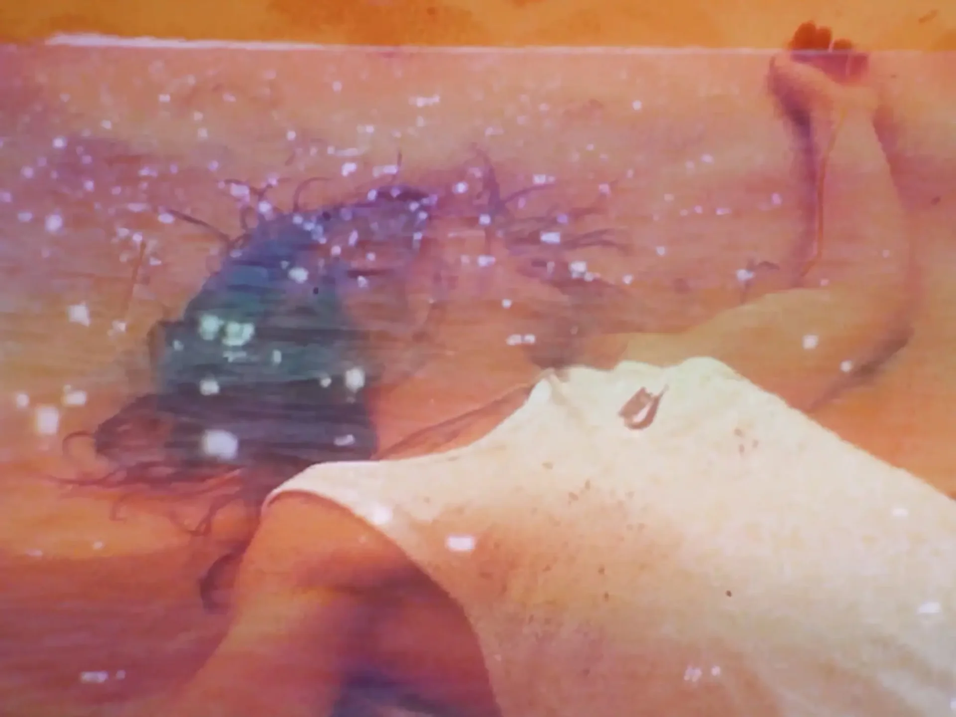Film still from Super8 short: Composite image—medium shot of someone lying in shallow water in a tank top superimposed over sunlight twinkling on waves.