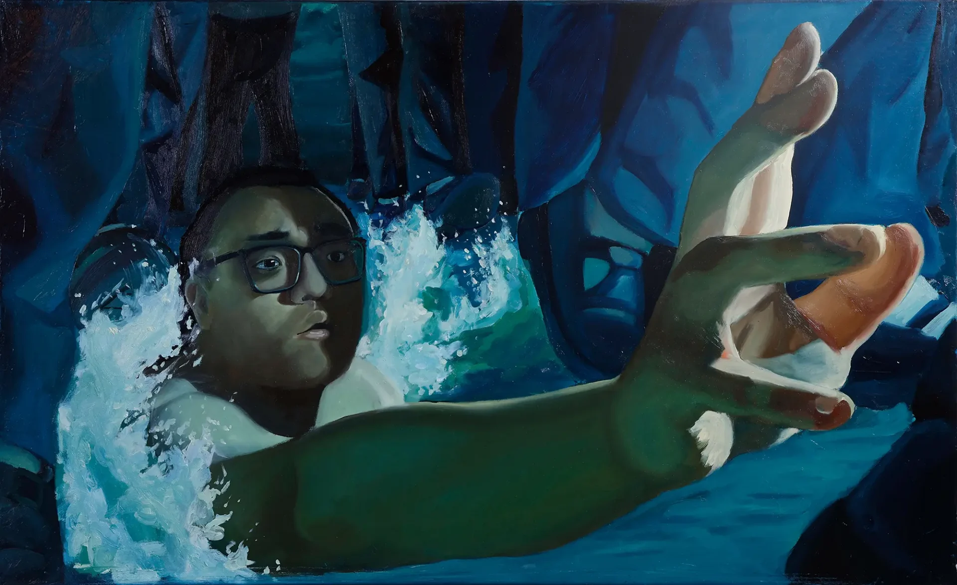 A boy wearing glasses reaches out while being pulled under waves