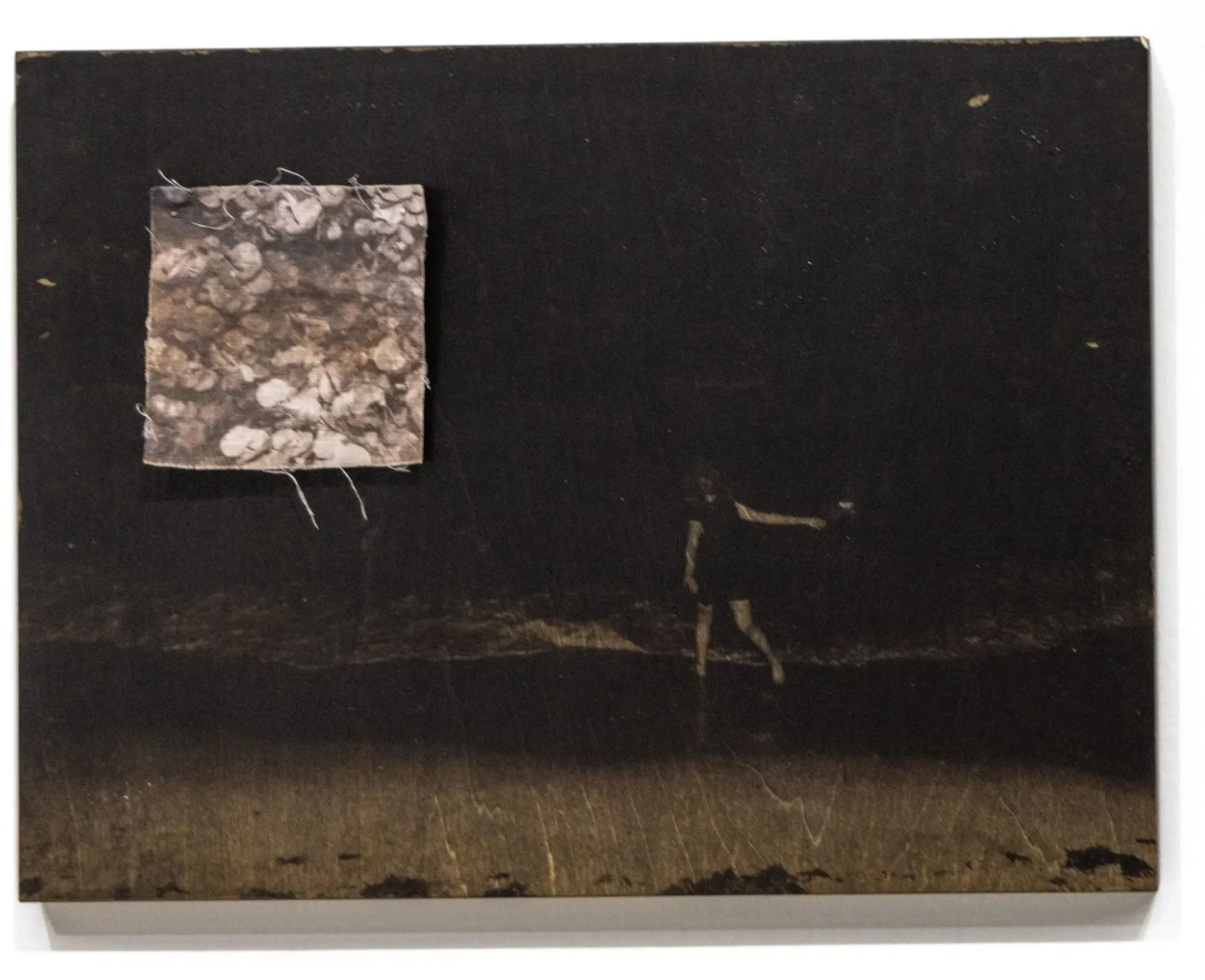 Image transfer on wood of a young woman walking into a body of water with cyanotype of water textures printed on fabric nailed as an inset.