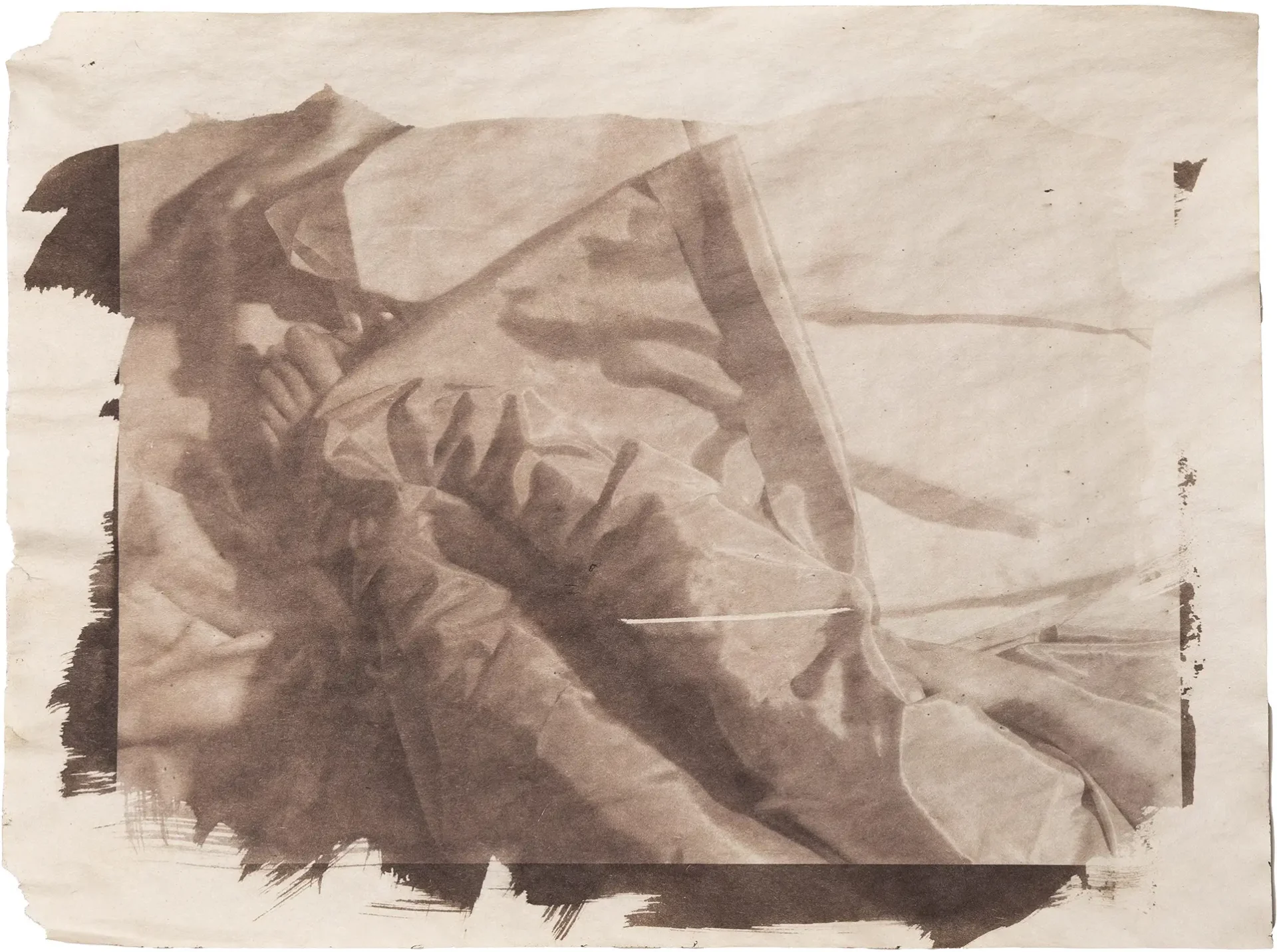 Van Dyke print of toes under fabric printed on newsprint.