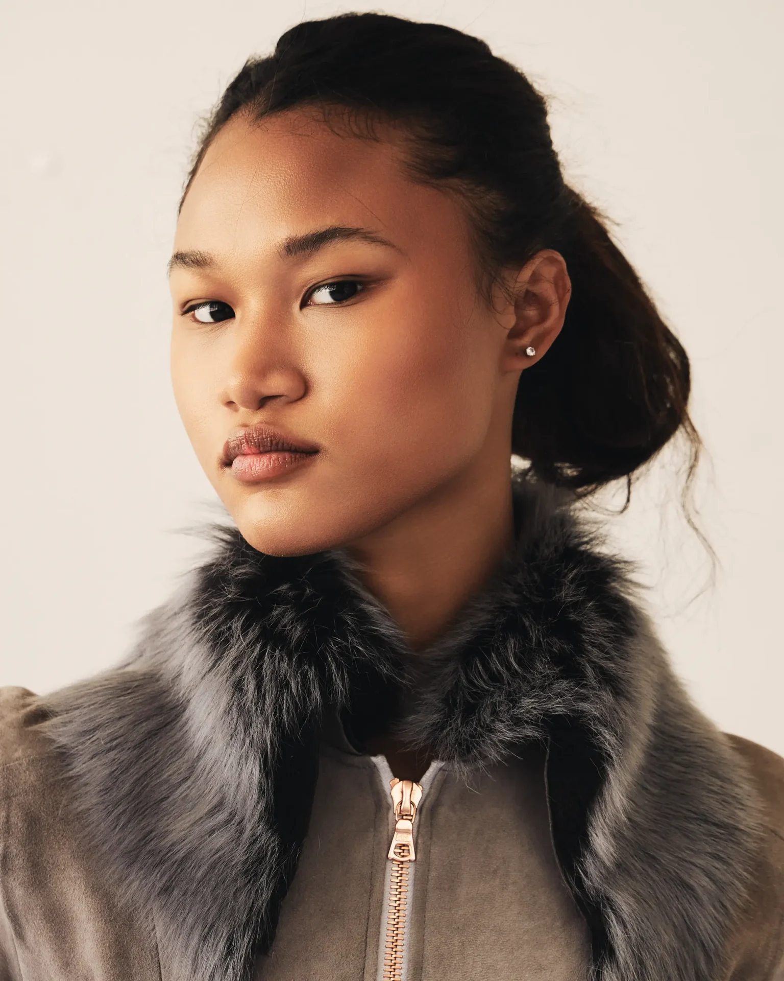 Model wearing suede coat with fur collar