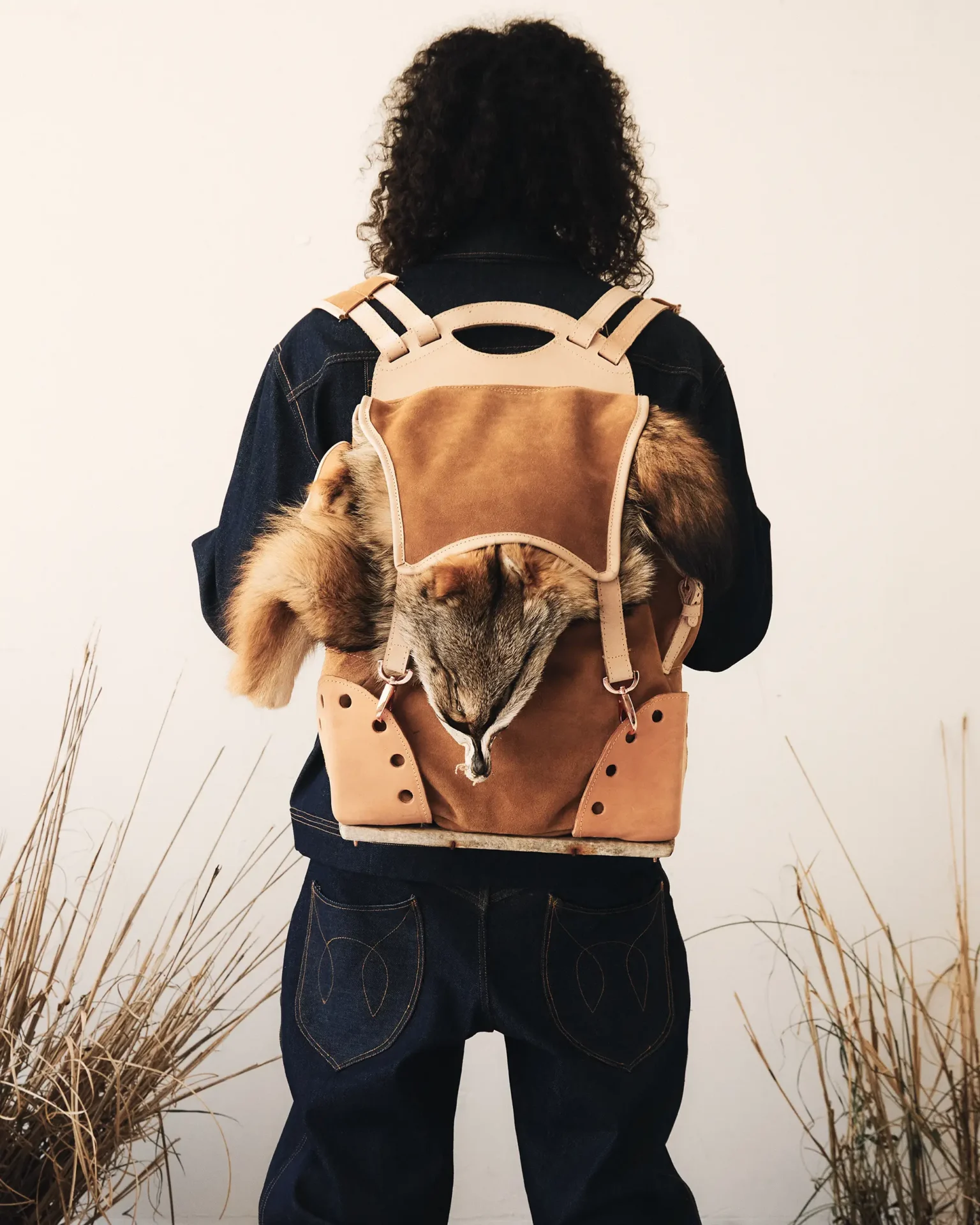 Model wearing backpack with animal hide