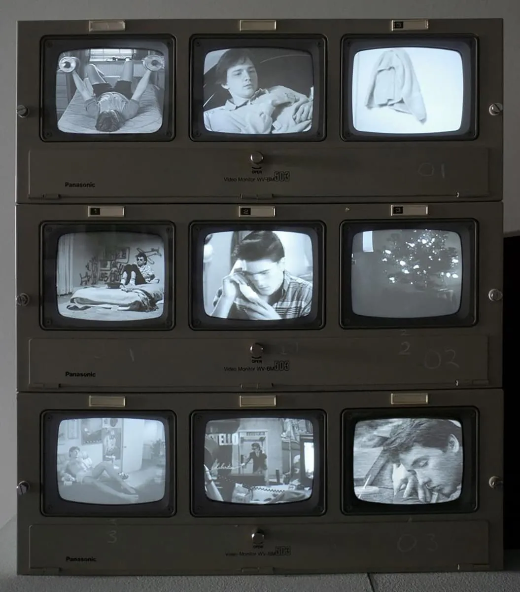 A series of 9 television screens featuring unique scenes of people on each screen