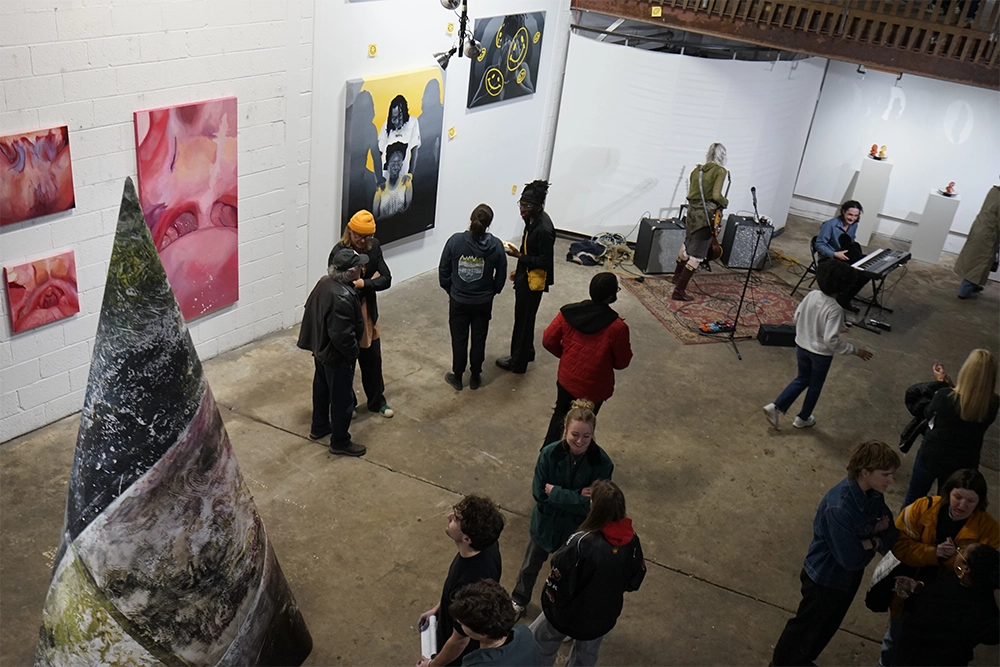 People mingle at an off-site gallery show of senior Studio Art & Craft thesis work.