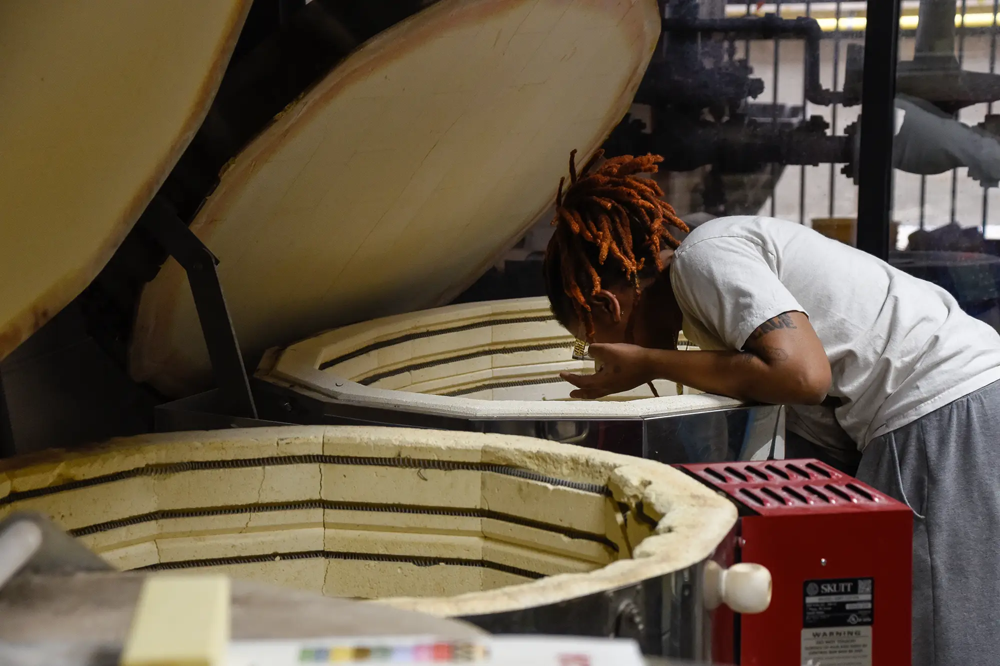 Student looking into kiln to discover how their project turned out.