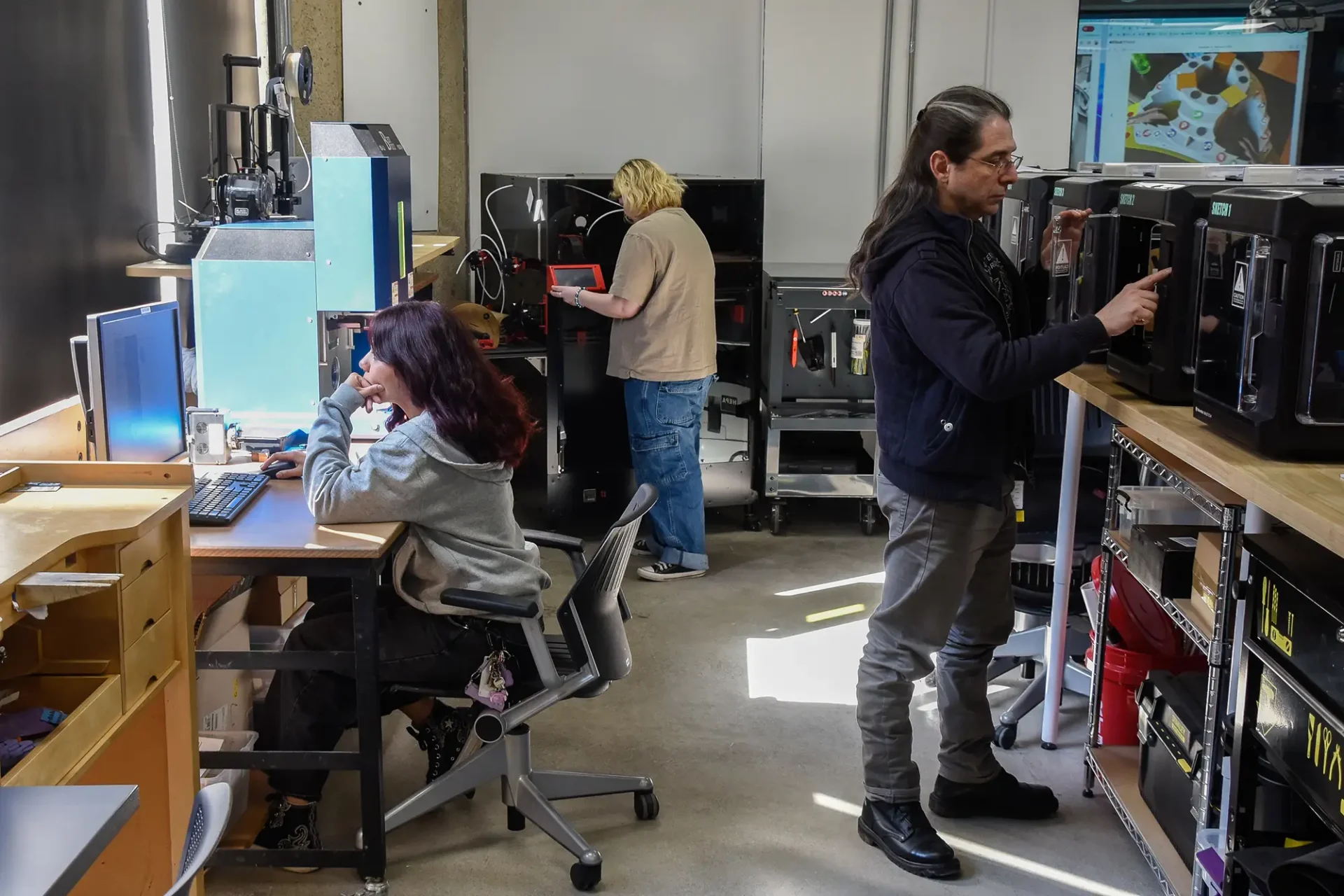 Students using laser printers and other innovative tools to creative their works of art.