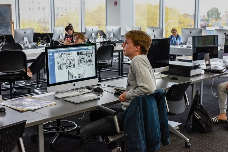 Visual Development students working in a high-tech classroom with industry-grade computers and wide windows.