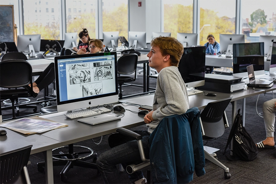 Visual Development students working in a high-tech classroom with industry-grade computers and wide windows.