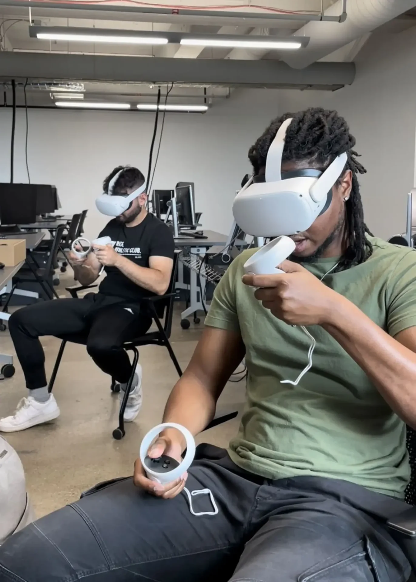 Two students in a work lab using VR headsets