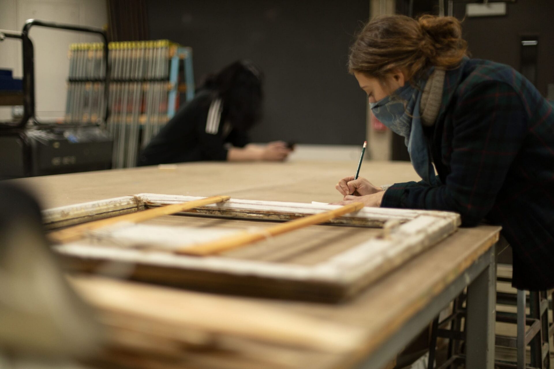A student leaning on a table making a measurement