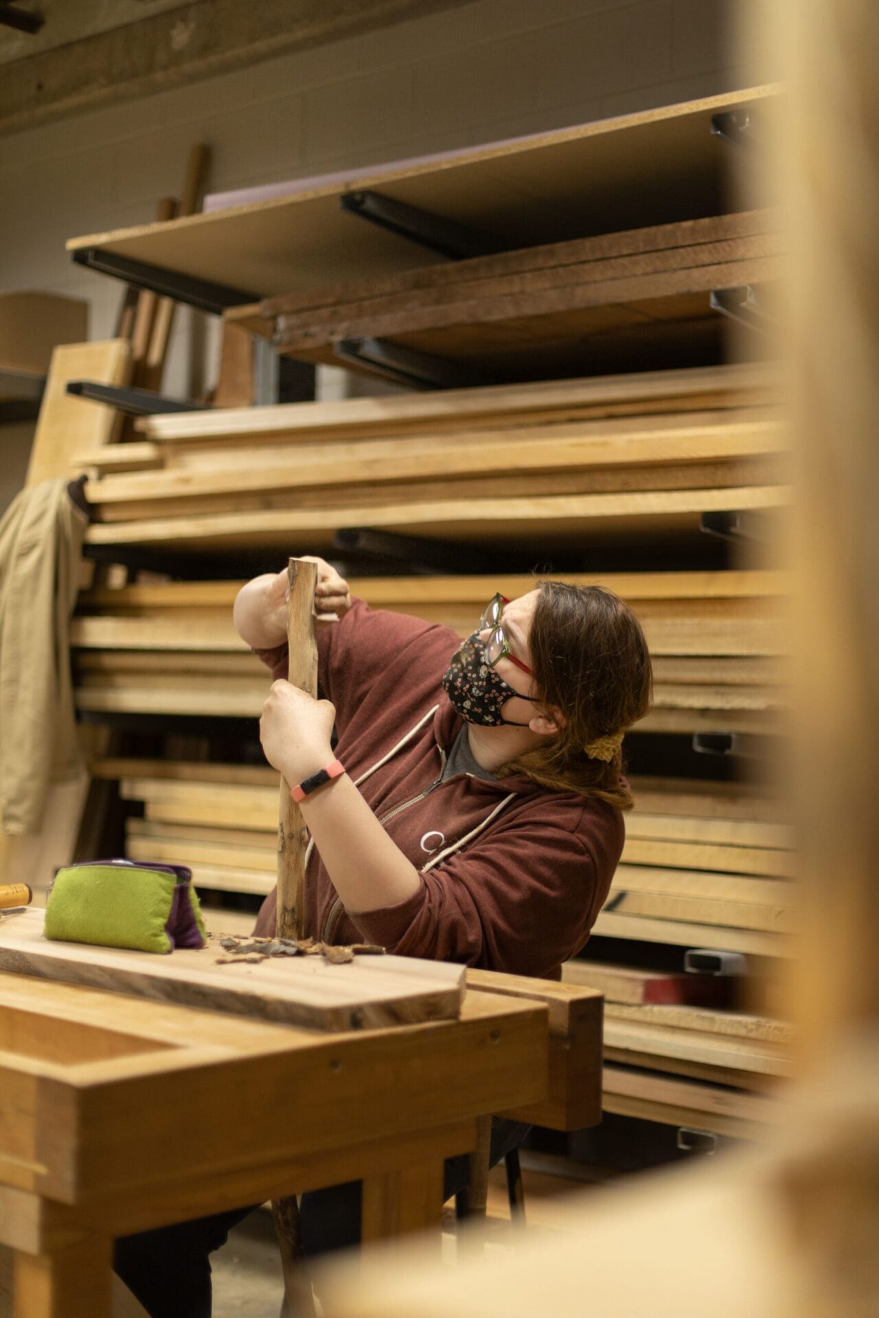 A student sanding down a long piece of wood