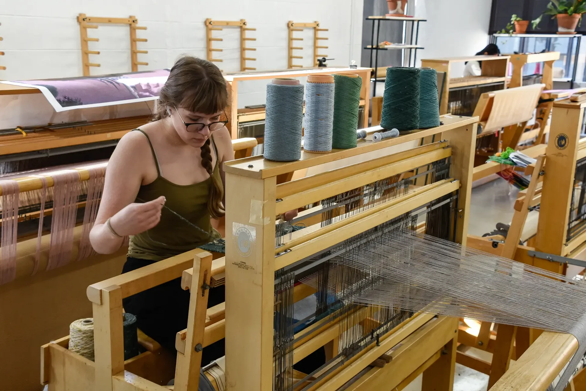 A student working on a loom