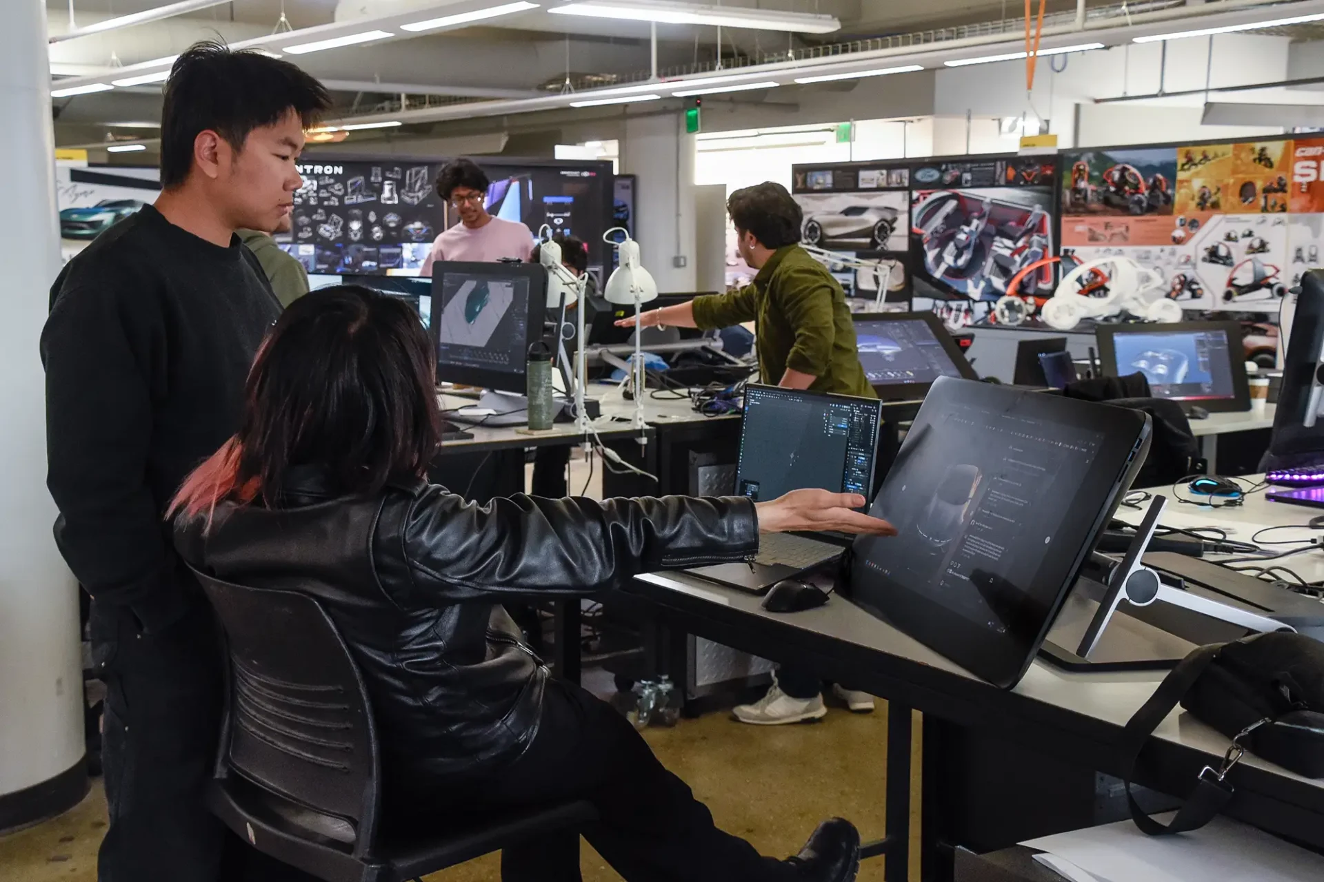 A student showing another some of their work on a wacom tablet in a studio