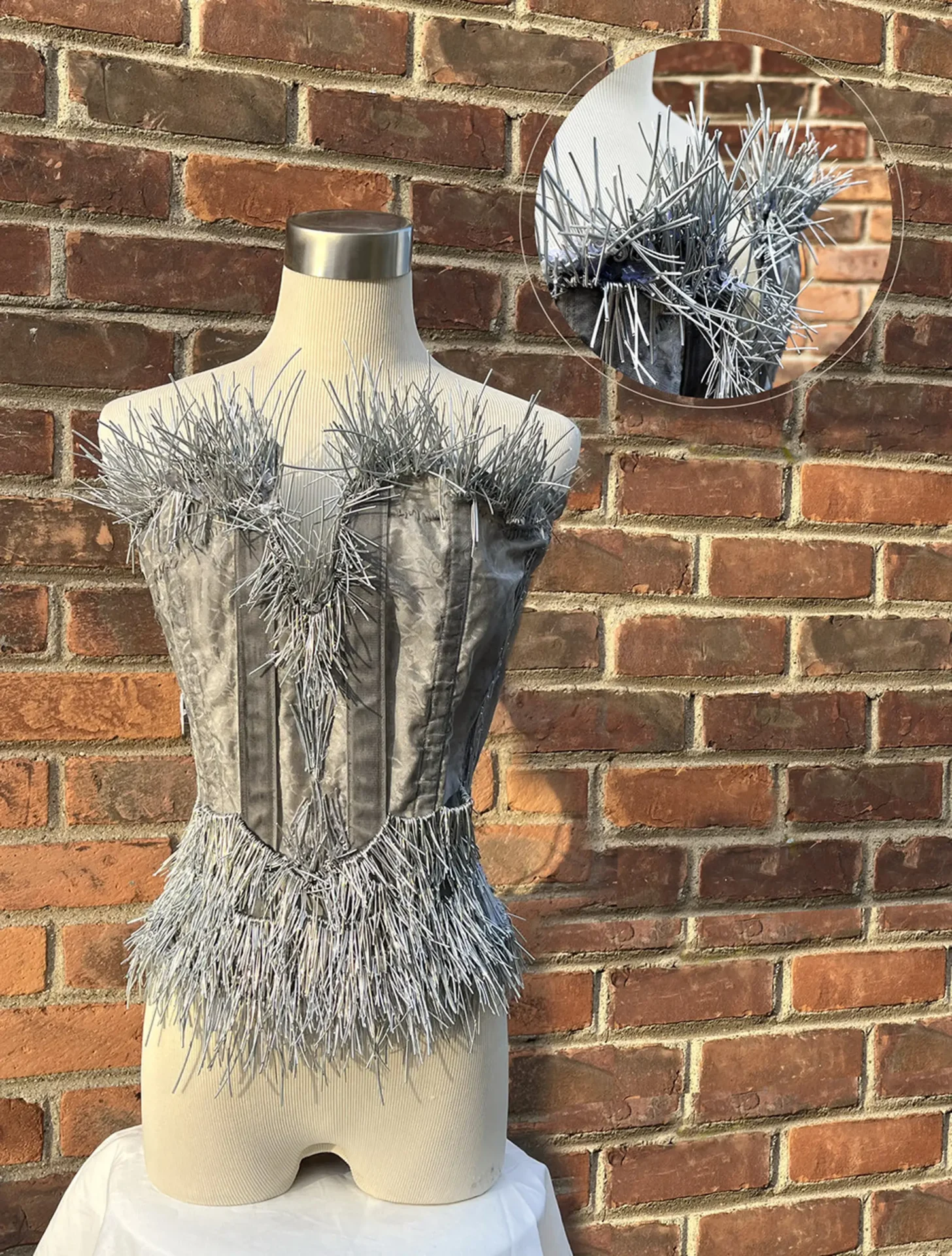A dress made of long fiber like strands on a bust
