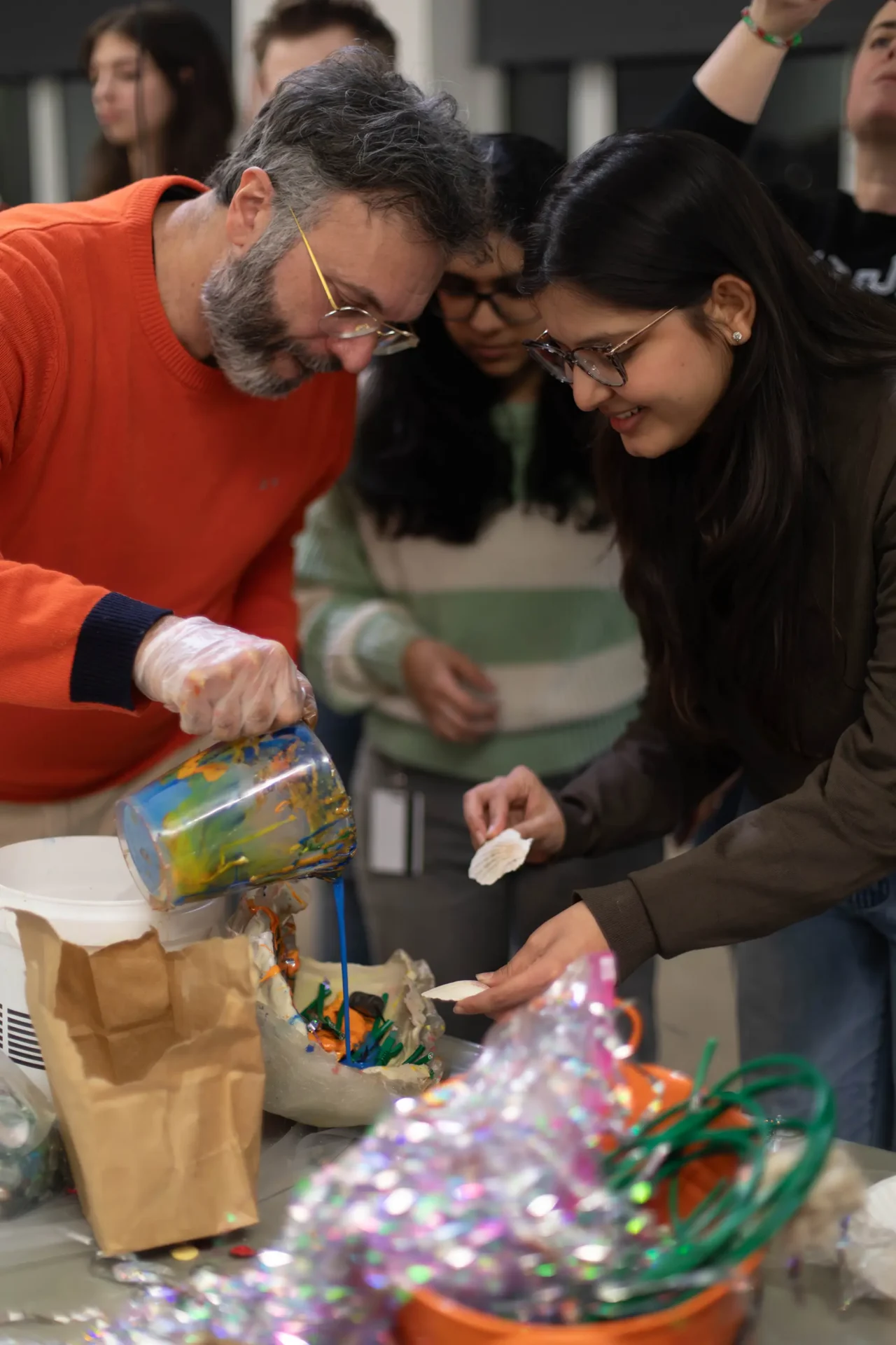 Visiting artist works with a student on a materials project.