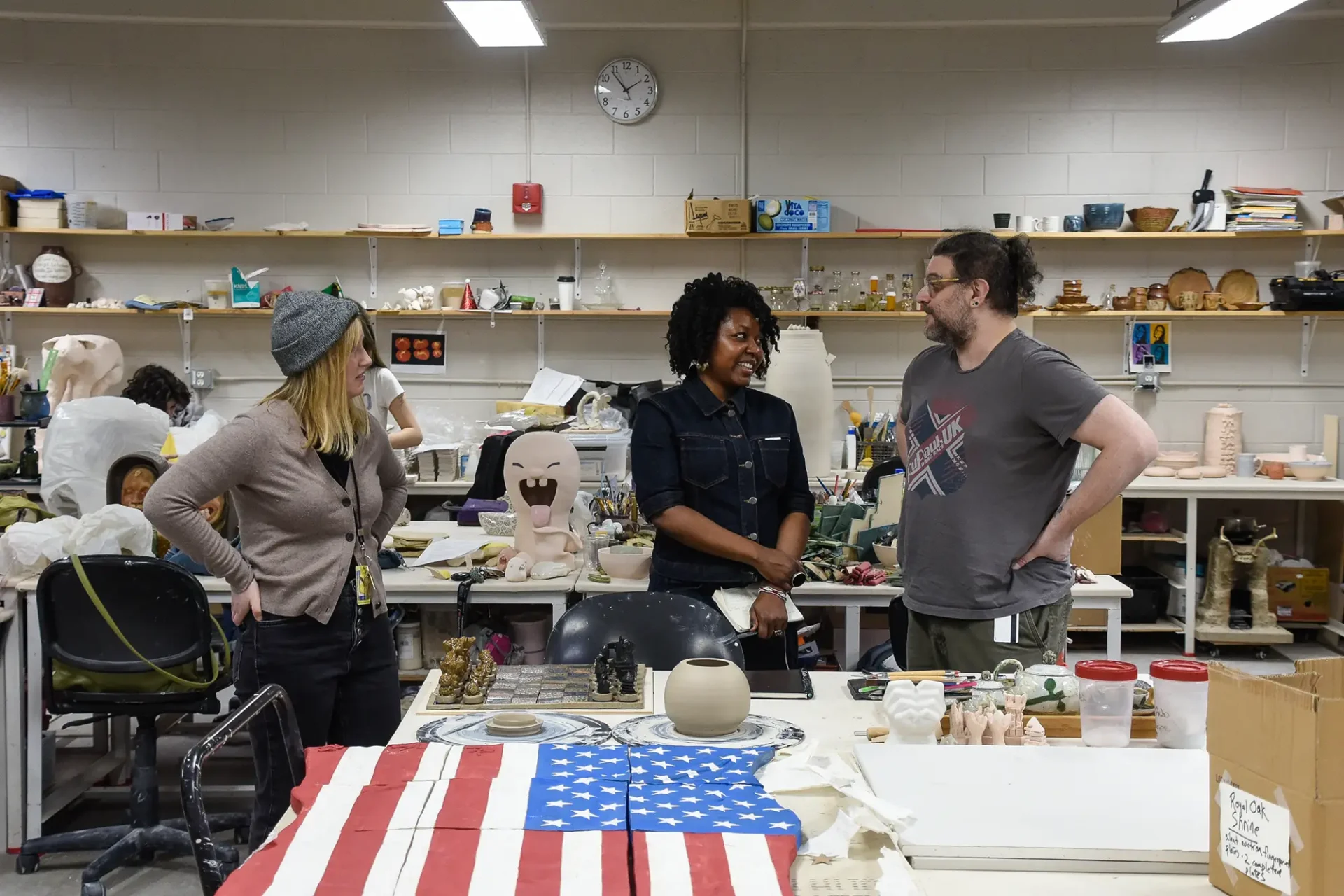 Visiting artist is working with a ceramics student sharing ways to refine their work.