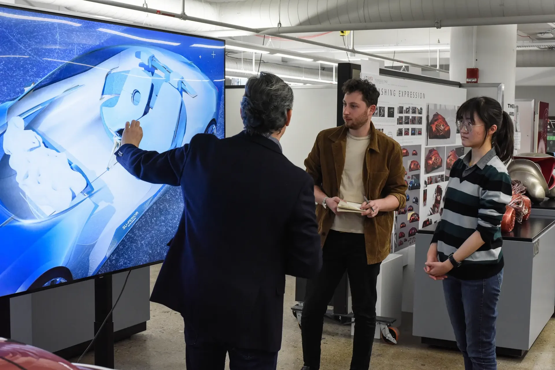 Graduate Professor discussing design with two students.