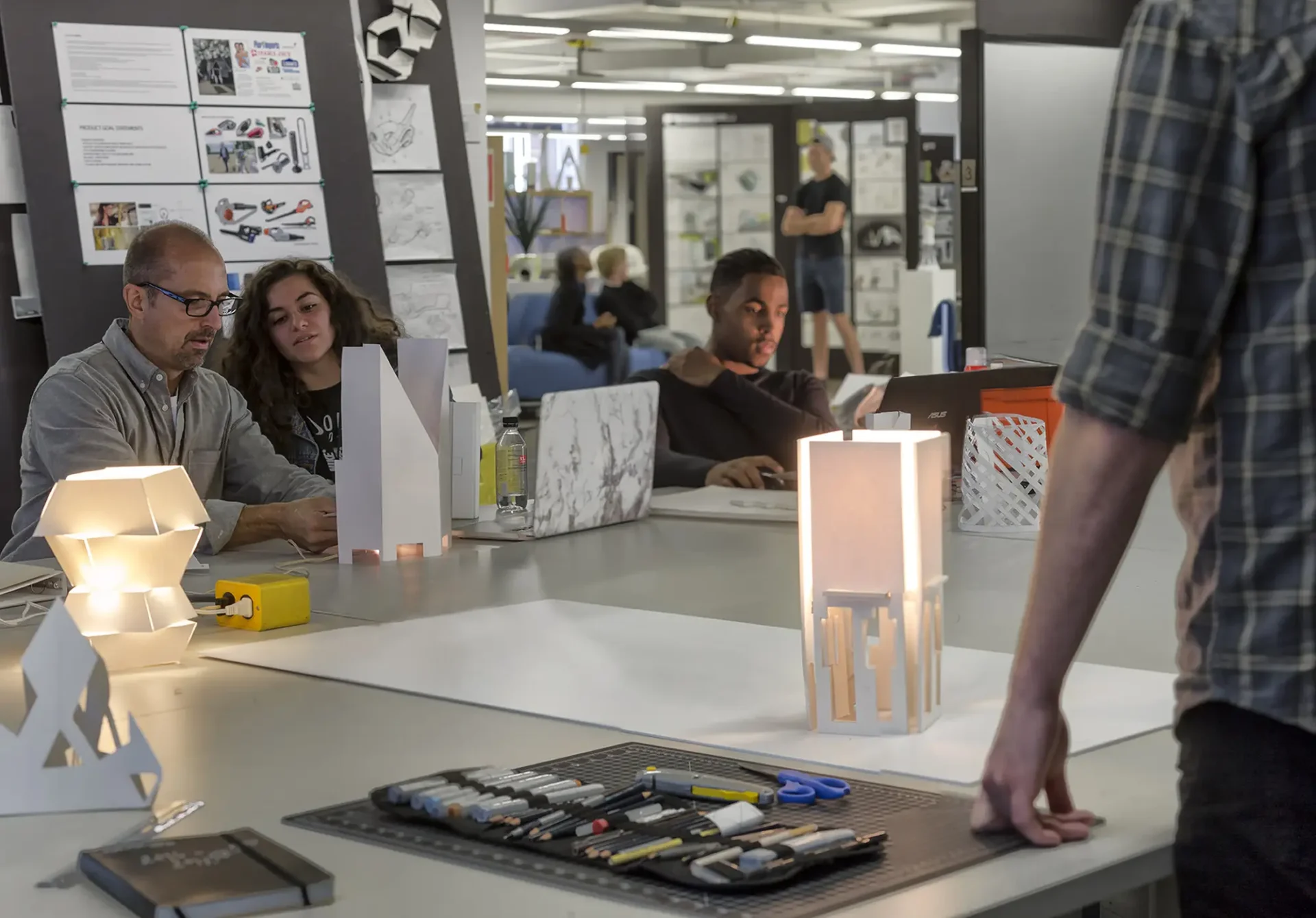 Professor working closely with a student for a 3D design project.