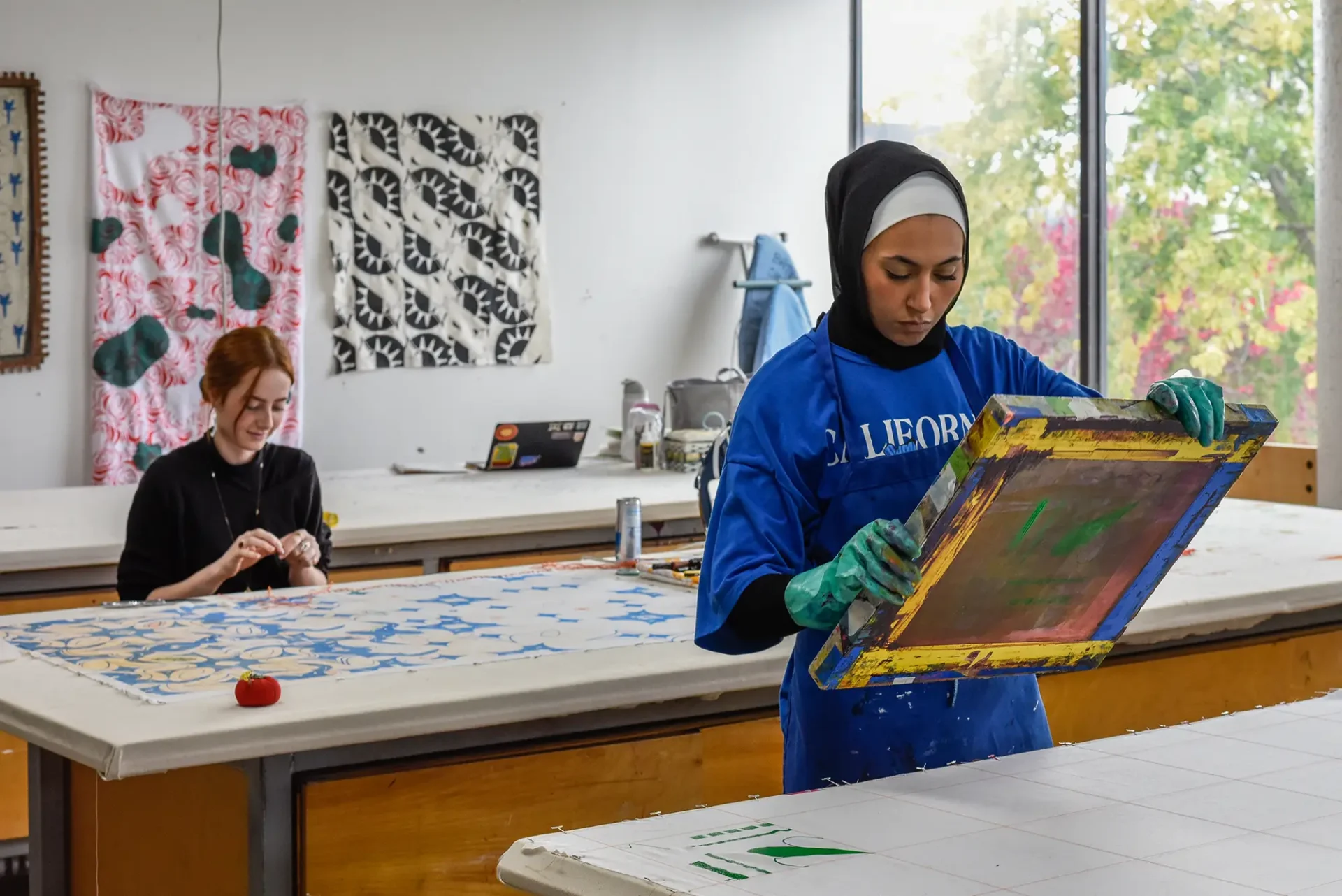 Woman silkscreening fabric in the Fiber Studio.