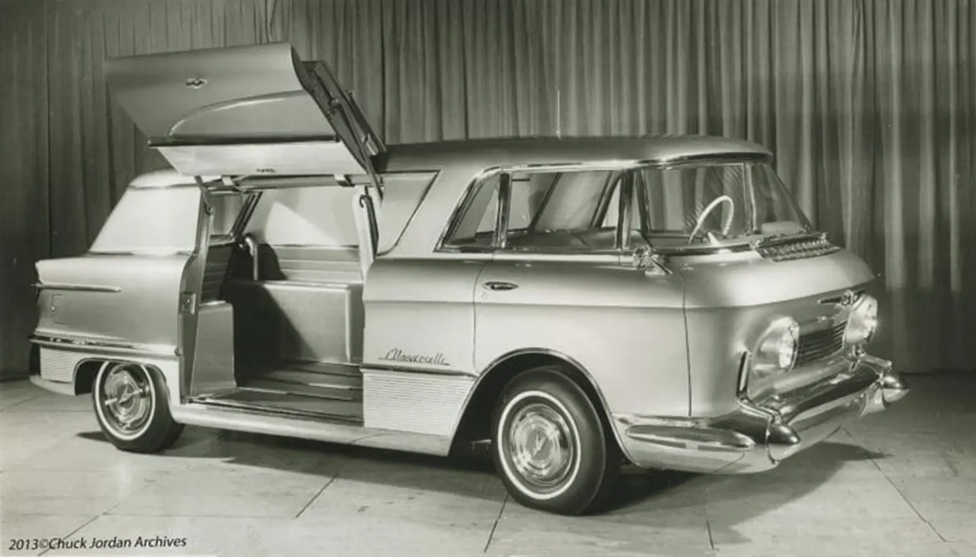 A side shot of a van with a passenger door opened, showing the interior of the backseat