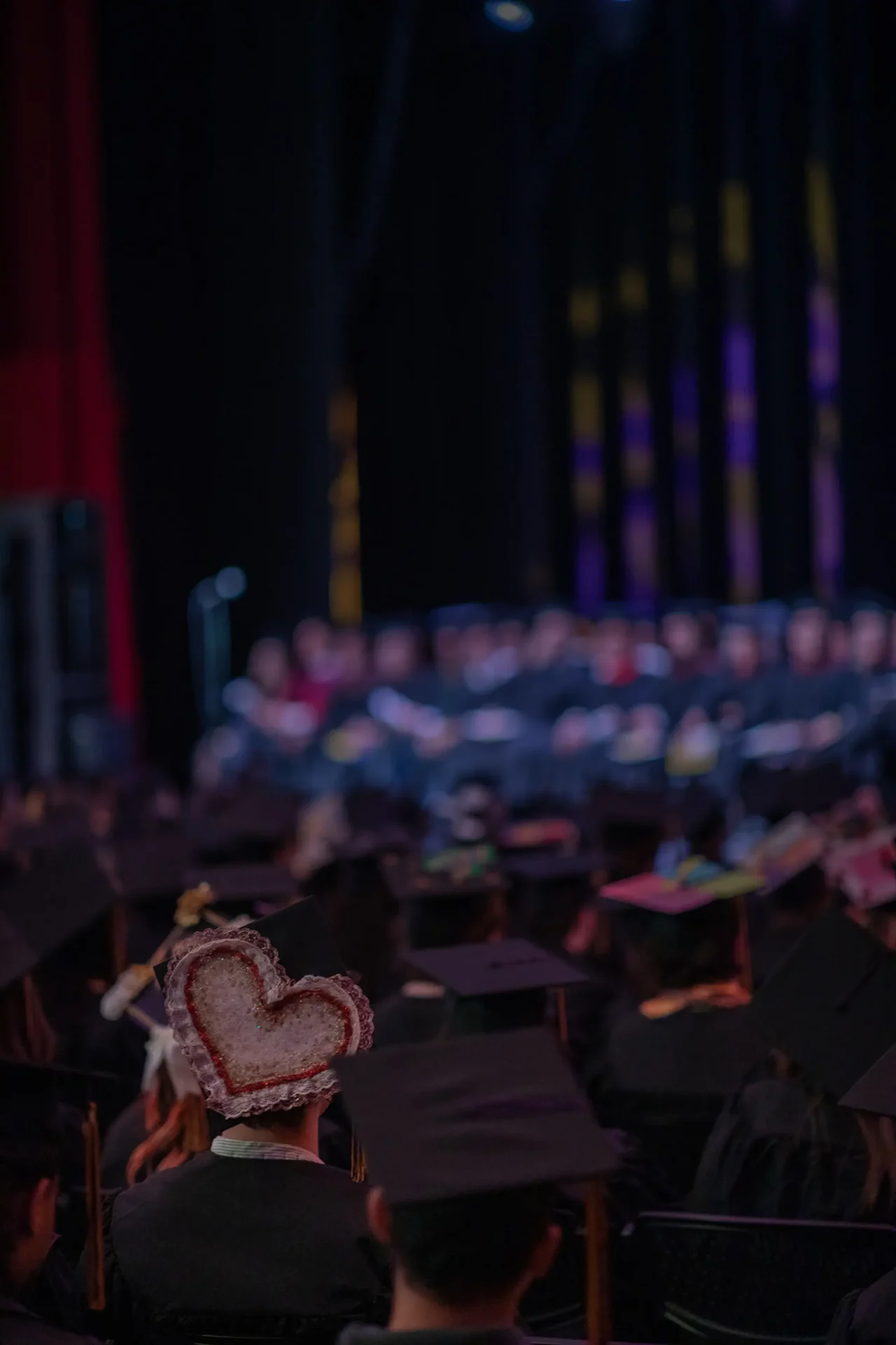 A student with a decorative heart on their graduation cap