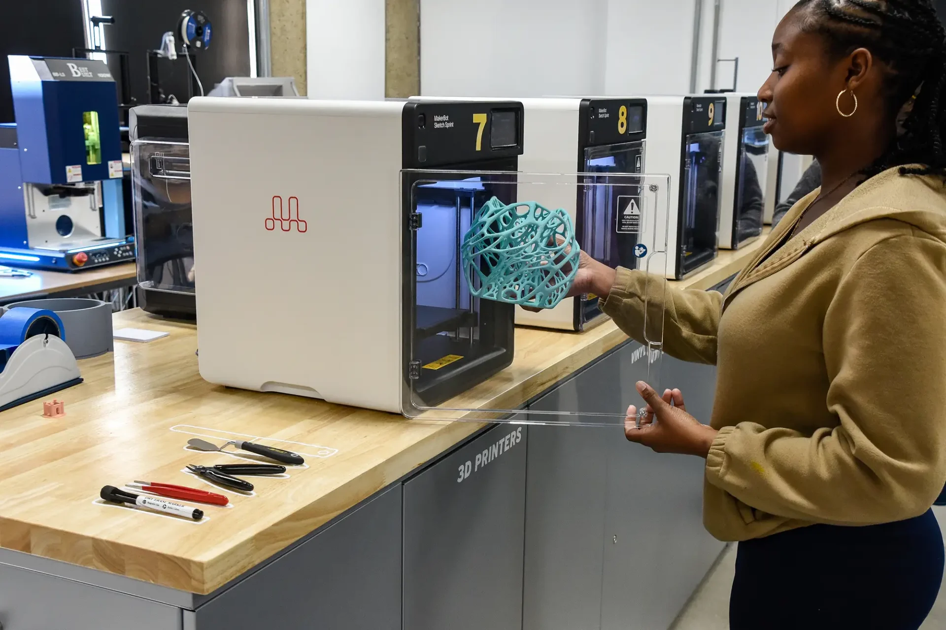 Student pulling out a 3D printed artifact.