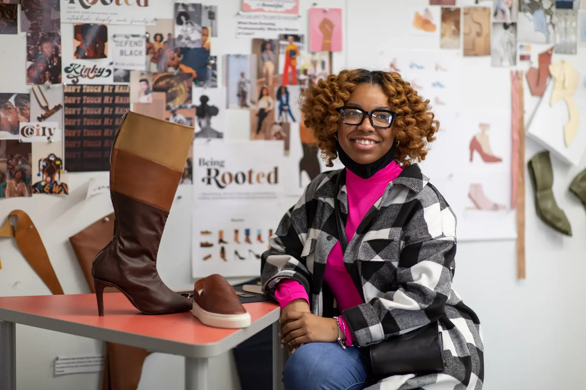 CCS student sitting next to her shoe design.