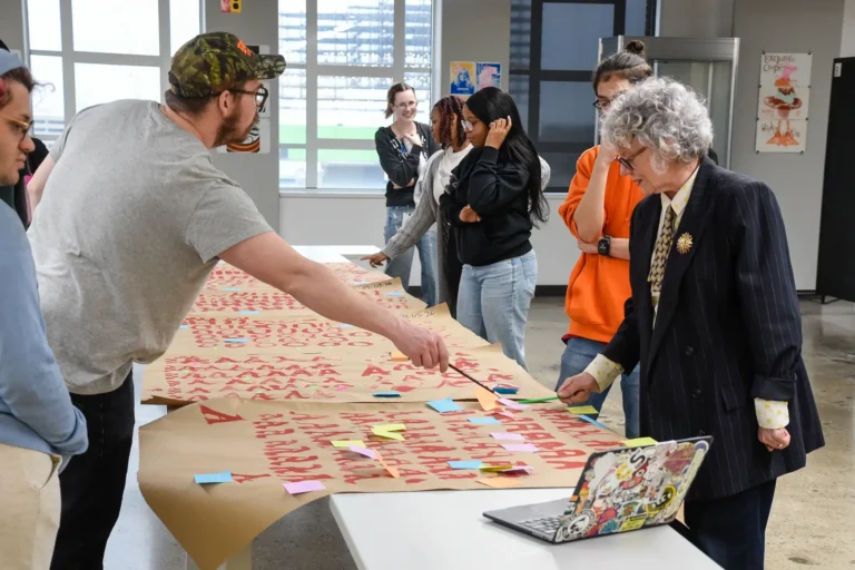 Student critiquing their work with faculty.