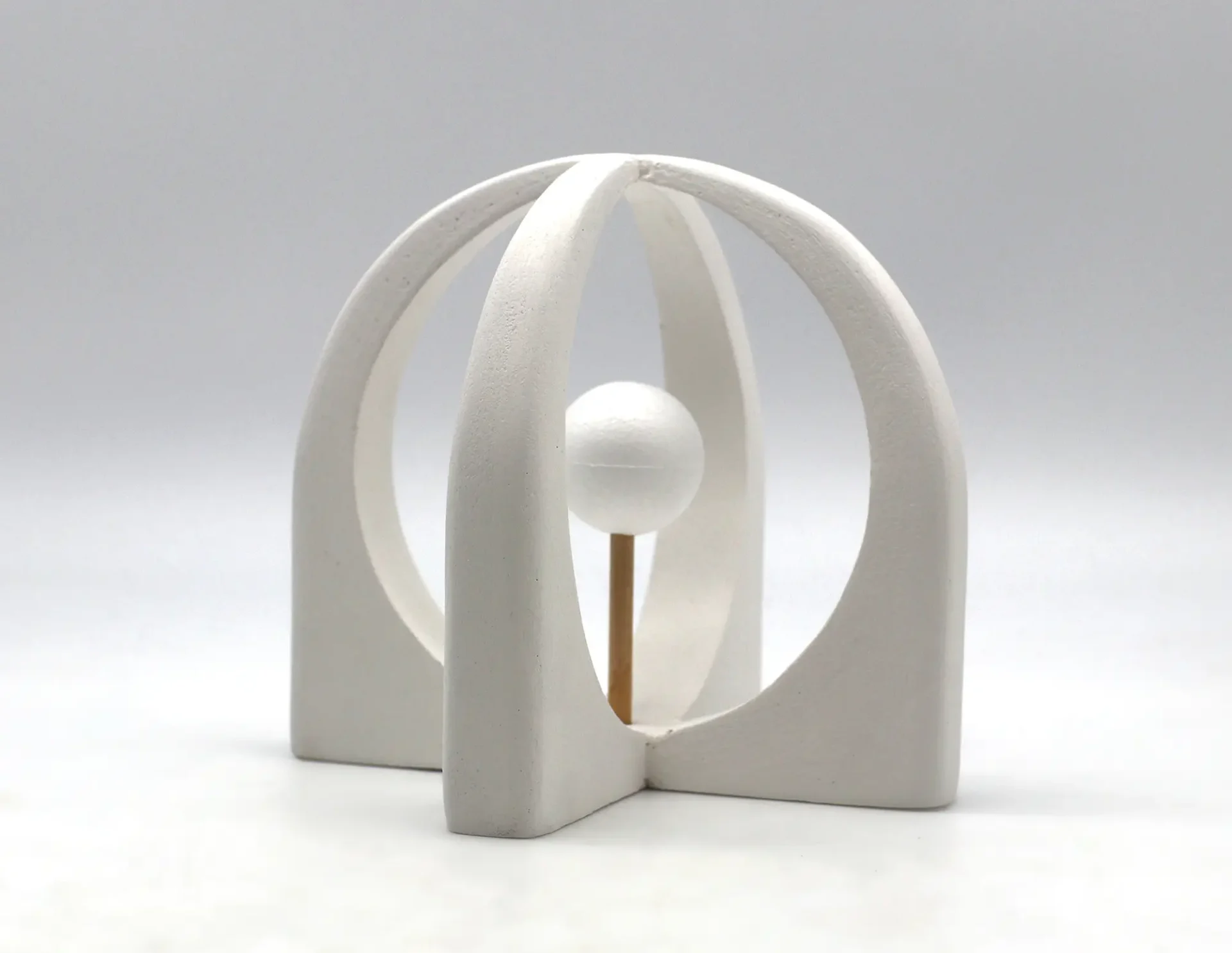 3D model of a white cage surrounding a small sphere.